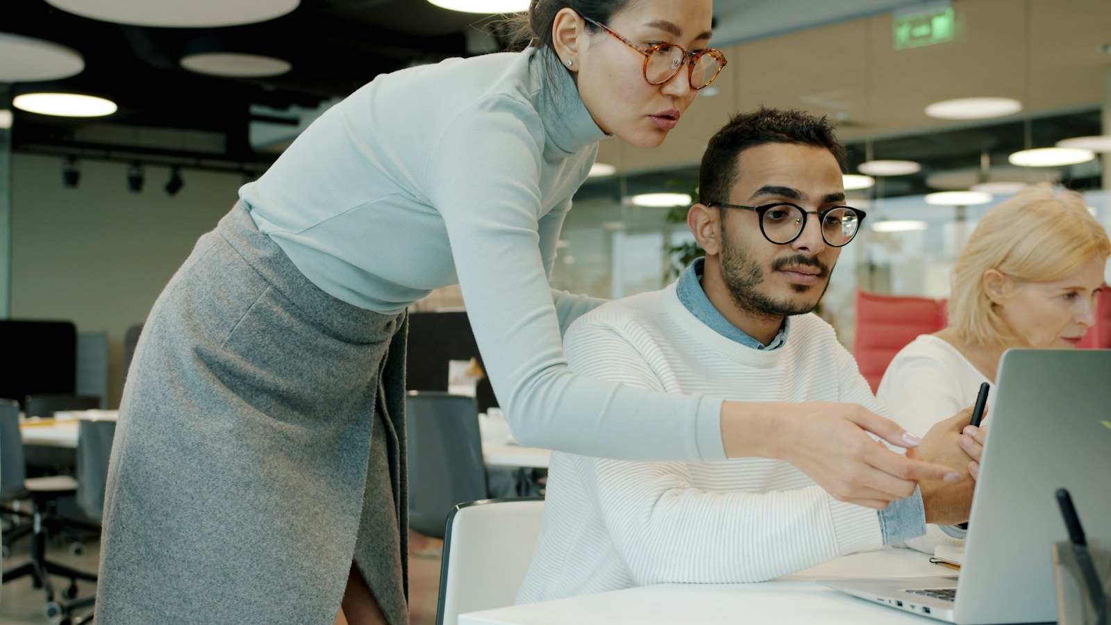 Two colleagues discussing work at a laptop